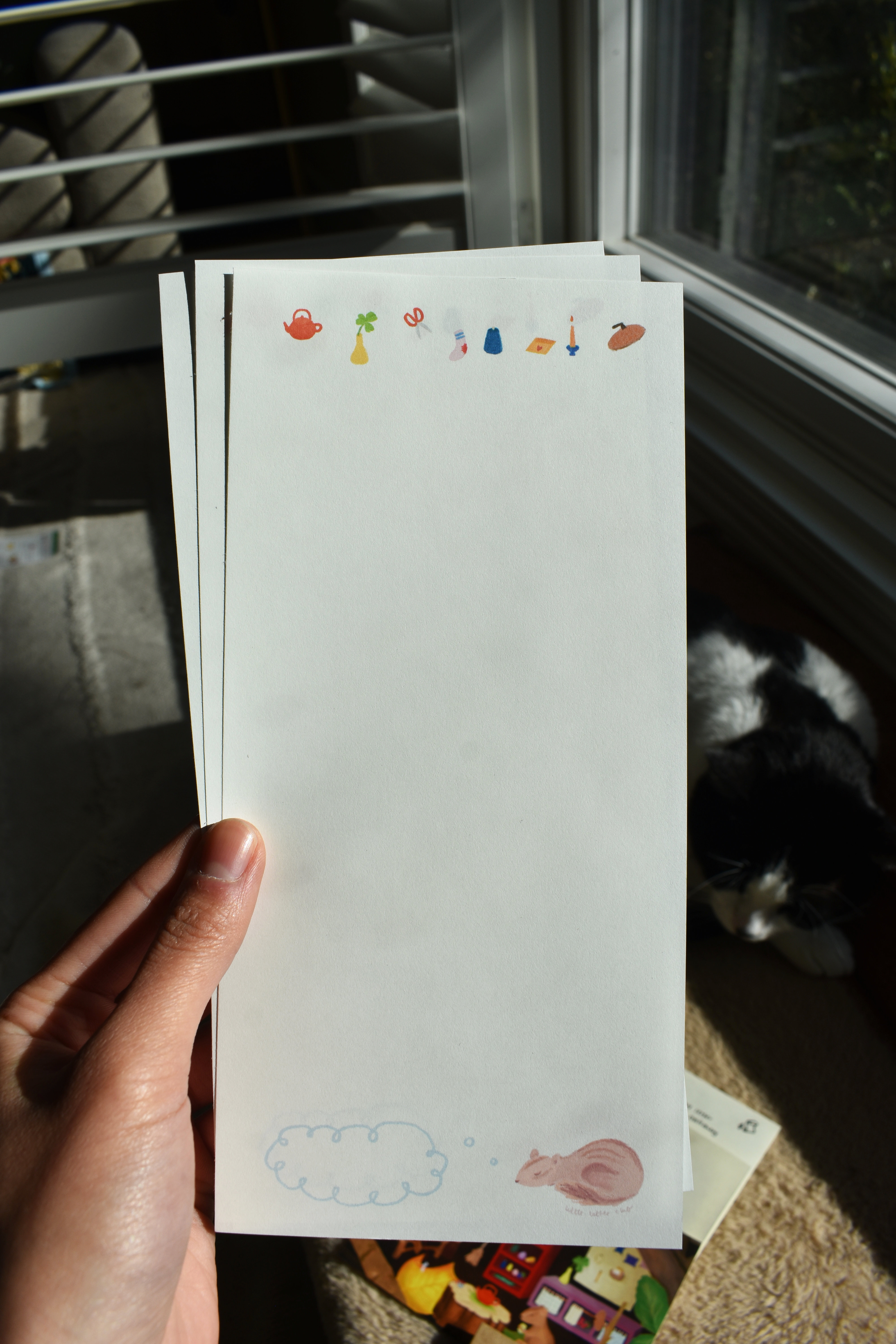 Closeup of stationery featuring sleeping chipmunks and cozy household items