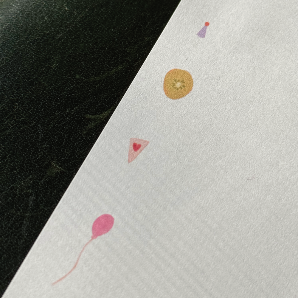 Closeup of stationery featuring little party icons